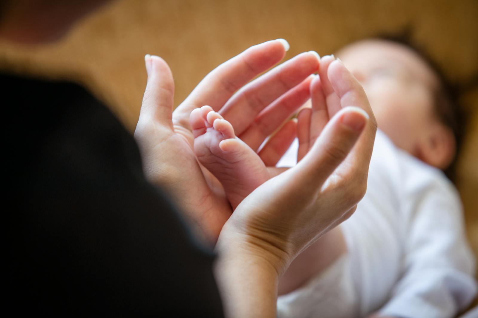 Tiny newborn feet on a soft white blanket