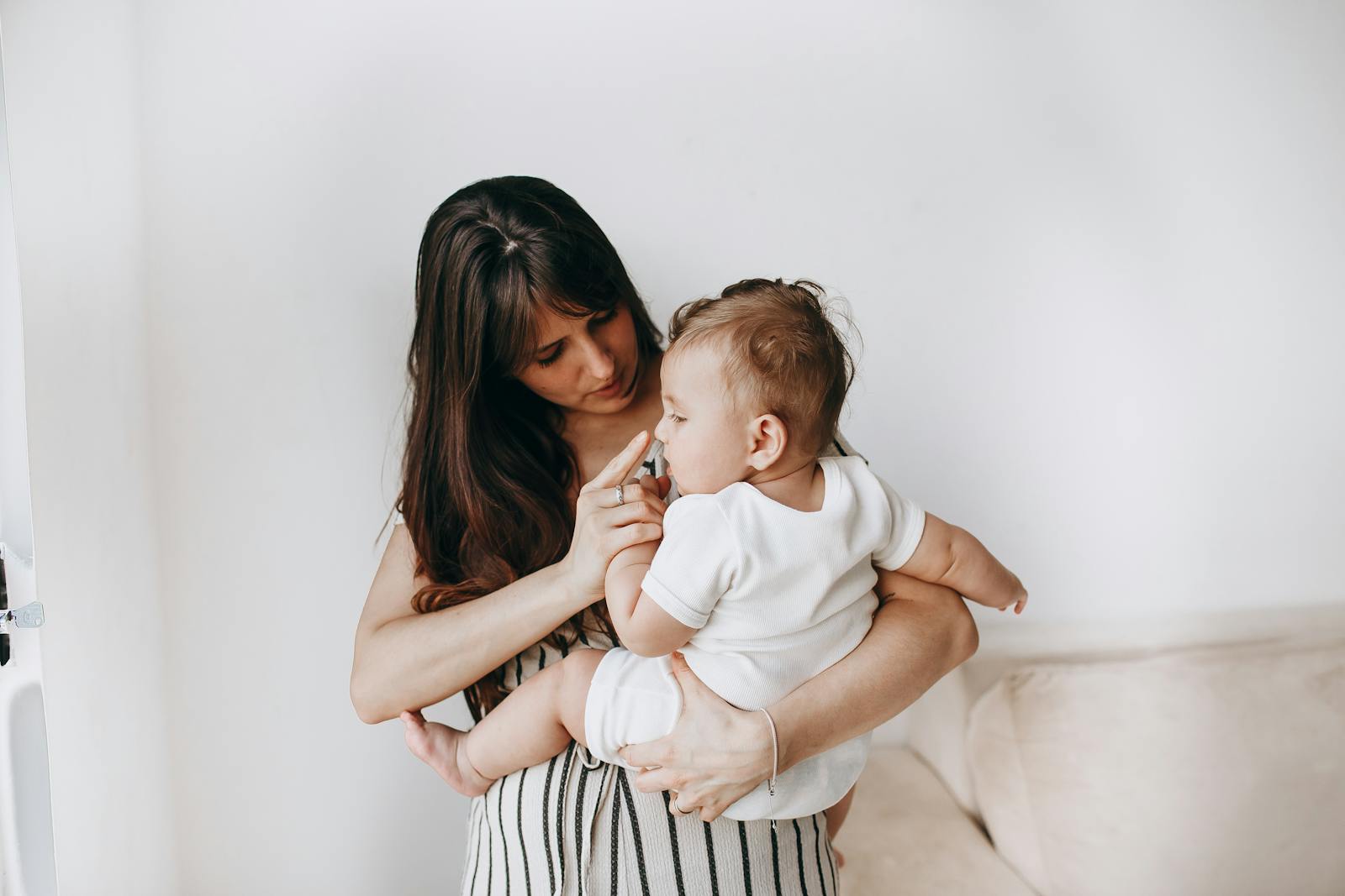 Tender moment of a mother and baby bonding together at home